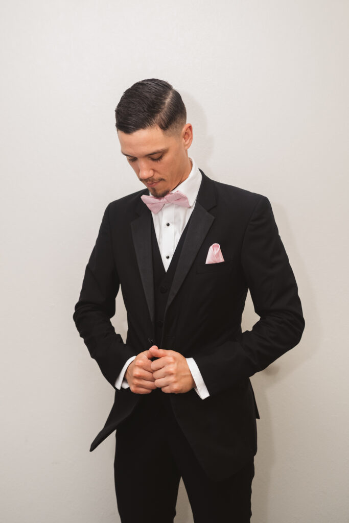 Portrait of the Groom holding his suit jacket and looking down, photographed by Philadelphia and New Jersey based travel wedding photographer, Madison Neumann Photography.