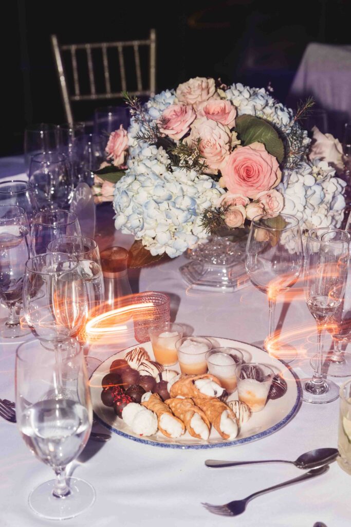 Closing shot of dinner table with floral centerpiece and dessert spread, photographed by Philadelphia and New Jersey based travel wedding photographer, Madison Neumann Photography.