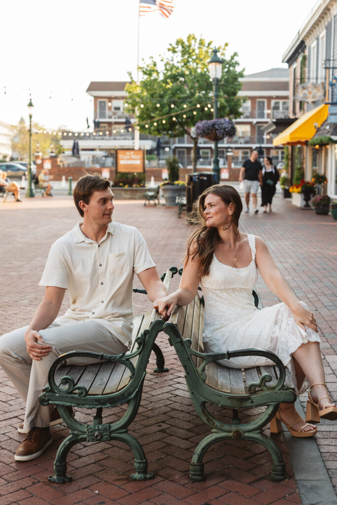Couple sitting on benches that are back-to-back as they turn to look at one another, photographed by Philadelphia and New Jersey based travel wedding photographer, Madison Neumann Photography.