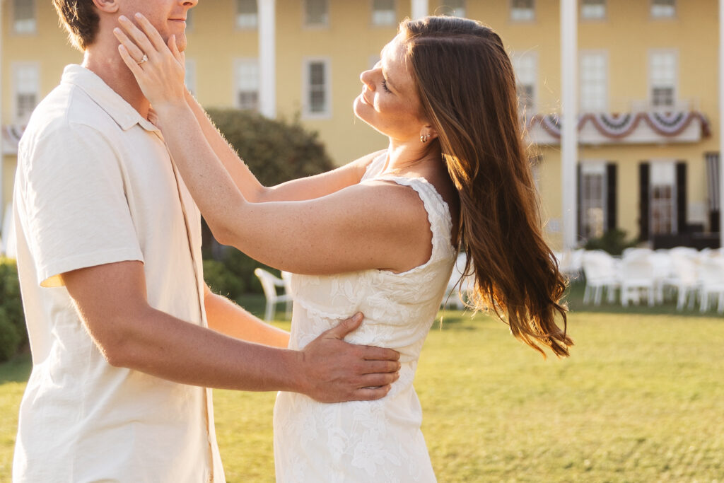 Couple poses on the grass with grooms hands on her waist and her hands on his face as they gaze lovingly at each other, photographed by Philadelphia and New Jersey based travel wedding photographer, Madison Neumann Photography.