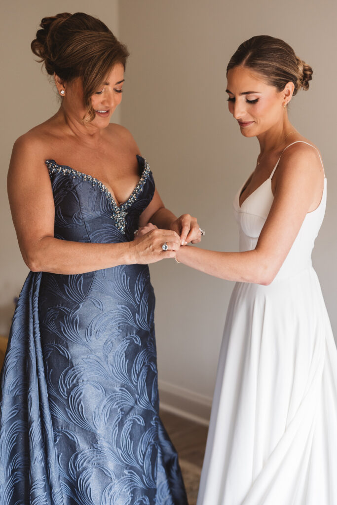 Bride and her mother getting ready and mom puts the bracelet on her daughter before the big day, photographed by Philadelphia and New Jersey based travel wedding photographer, Madison Neumann Photography.