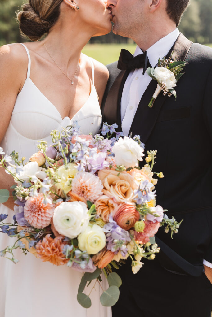 Detail shot of the bride and groom in their wedding attire and the brides bouquet as they kiss, photographed by Philadelphia and New Jersey based travel wedding photographer, Madison Neumann Photography.