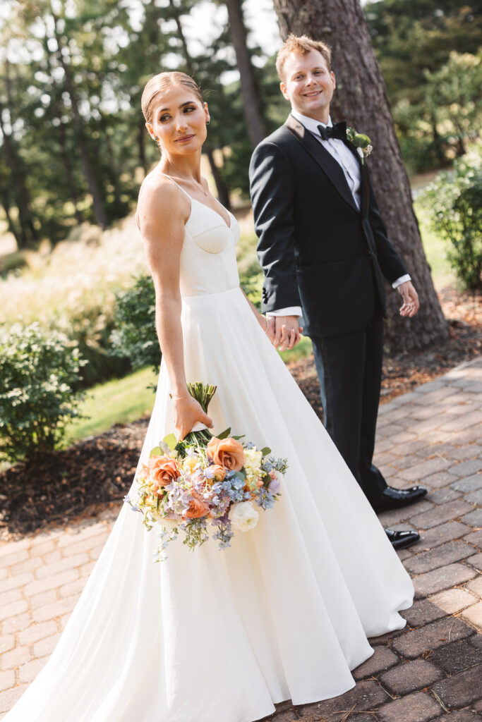 Groom leads his bride as they look back at the camera with a smile, photographed by Philadelphia and New Jersey based travel wedding photographer, Madison Neumann Photography.
