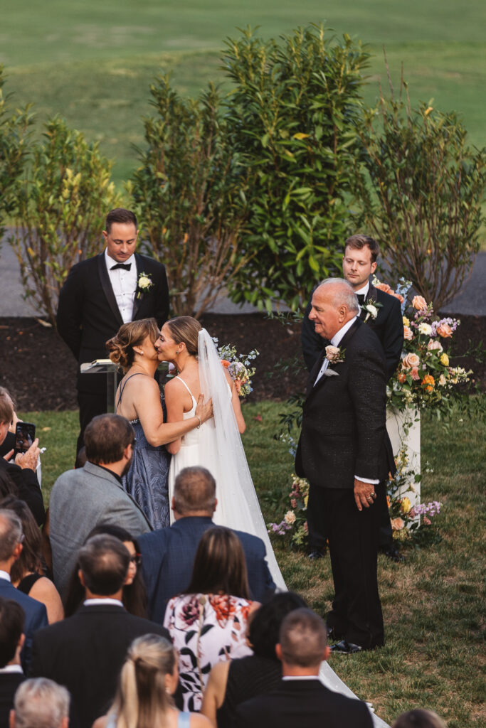 Bride kisses her mother and father before joining her groom at the altar shot from above, photographed by Philadelphia and New Jersey based travel wedding photographer, Madison Neumann Photography.