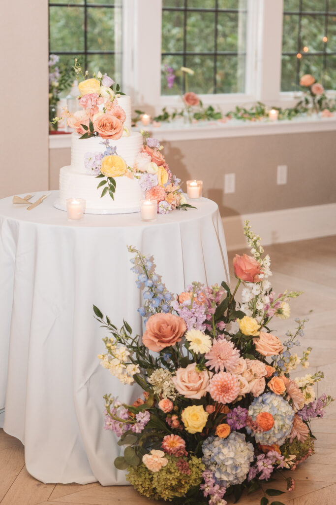 Wedding cake table with florals both surrounding and decorating the cake, photographed by Philadelphia and New Jersey based travel wedding photographer, Madison Neumann Photography.