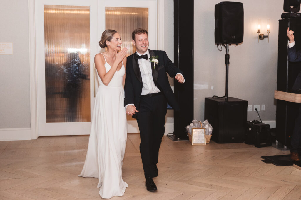Bride and groom enter their reception celebration with smiles on their faces, photographed by Philadelphia and New Jersey based travel wedding photographer, Madison Neumann Photography.