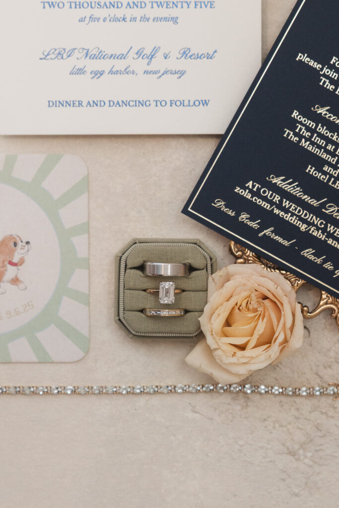 Flat lay of the rings and details such as the brides bracelet, flowers, coaster, and invitations photographed by Philadelphia and New Jersey based travel wedding photographer, Madison Neumann Photography.