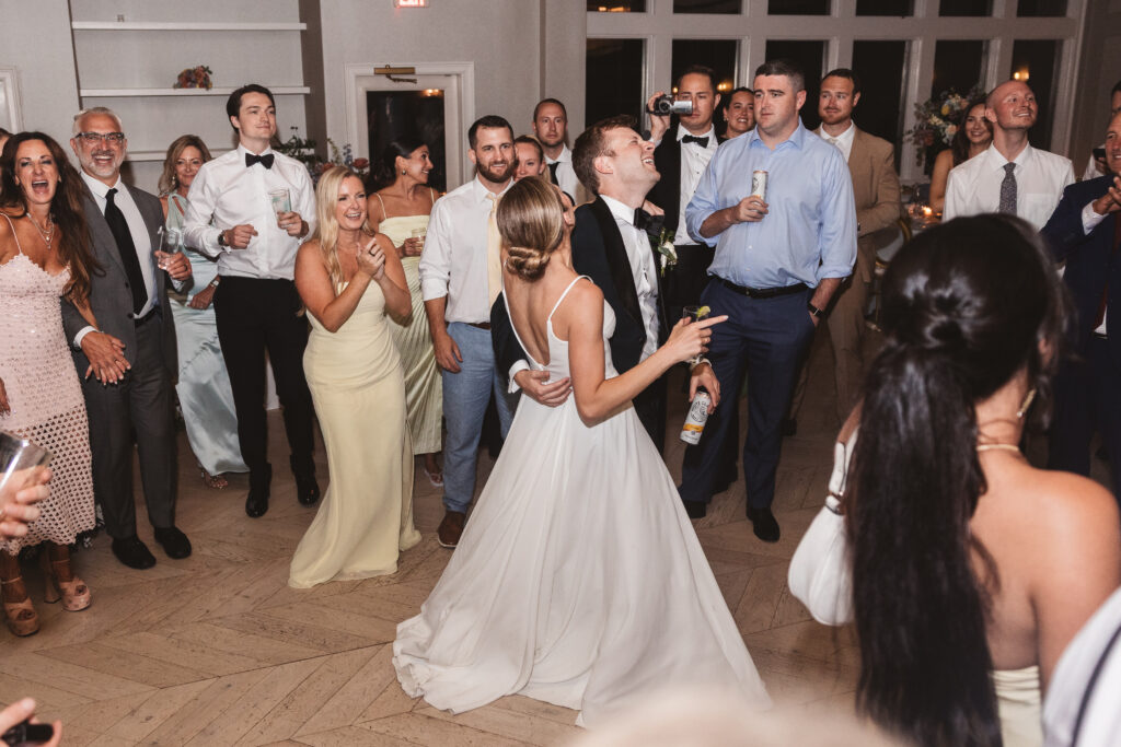 Bride and groom on the dance floor as groom holds his wife as they sing together with drinks in hand, photographed by Philadelphia and New Jersey based travel wedding photographer, Madison Neumann Photography.